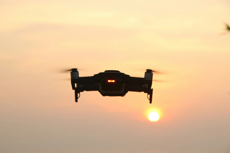 a small aircraft flying through the air at sunset