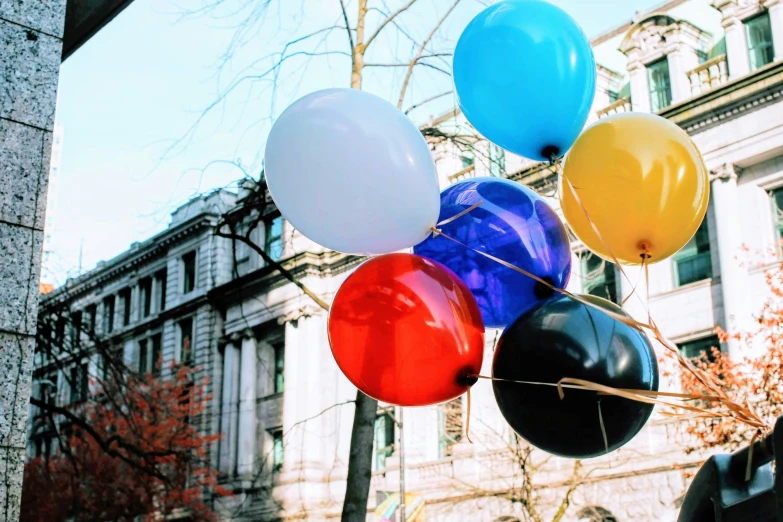 a bunch of balloons on a street pole