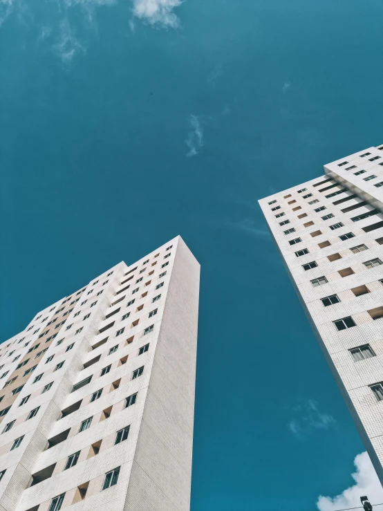 two high rise buildings in a clear, blue sky