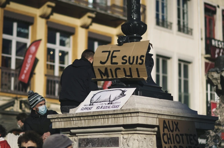 men standing on a sidewalk near a statue and sign