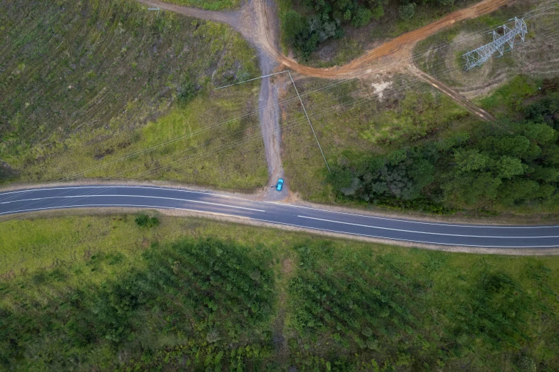 the aerial view of a highway with trees and grass