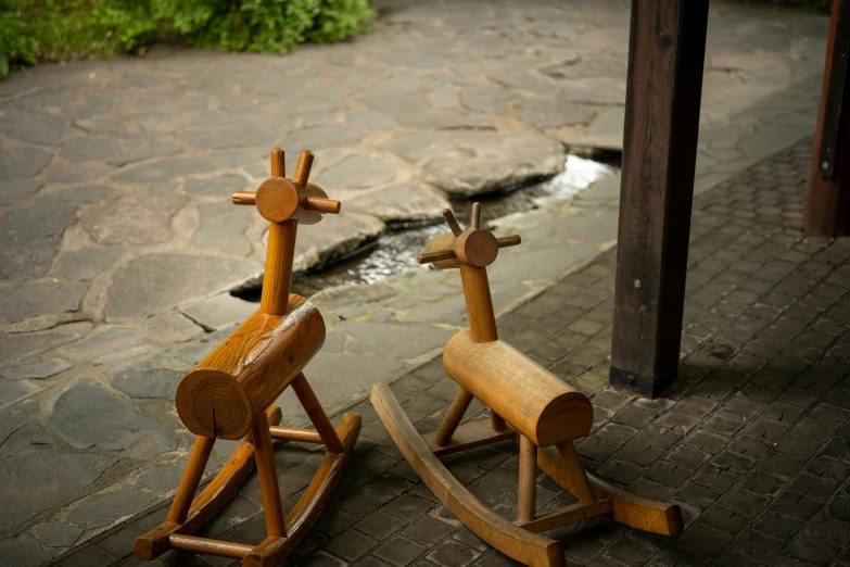 two wood statues of deers that are next to each other