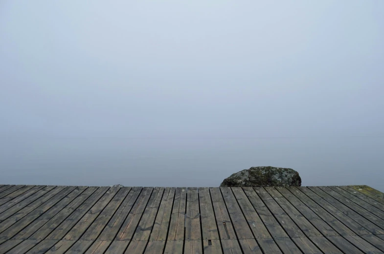 a large stone sits on the edge of a dock