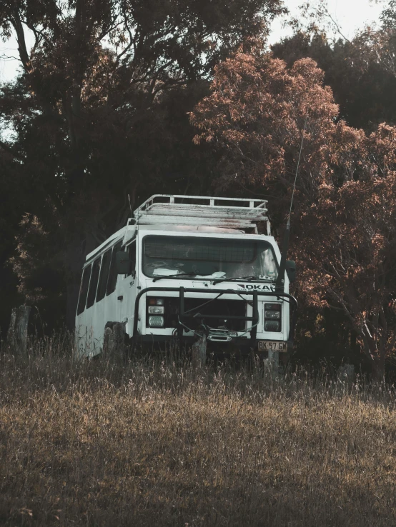 an old, run down van sitting in a wooded field