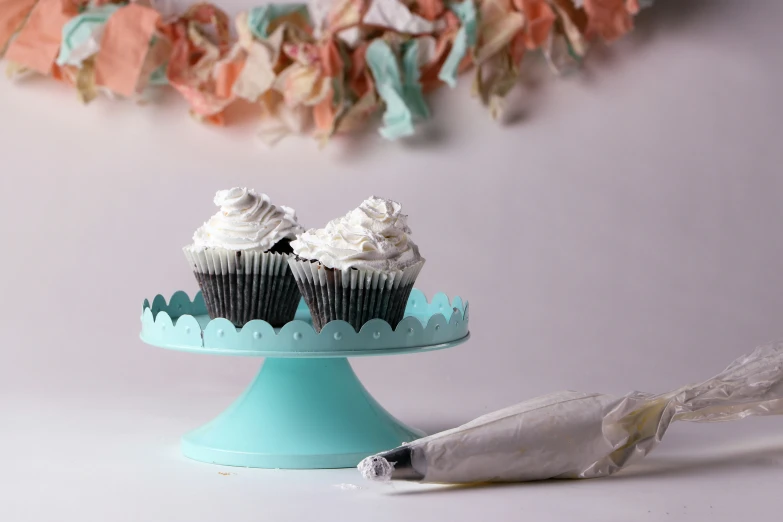 cupcakes on a blue cake platter with frosting