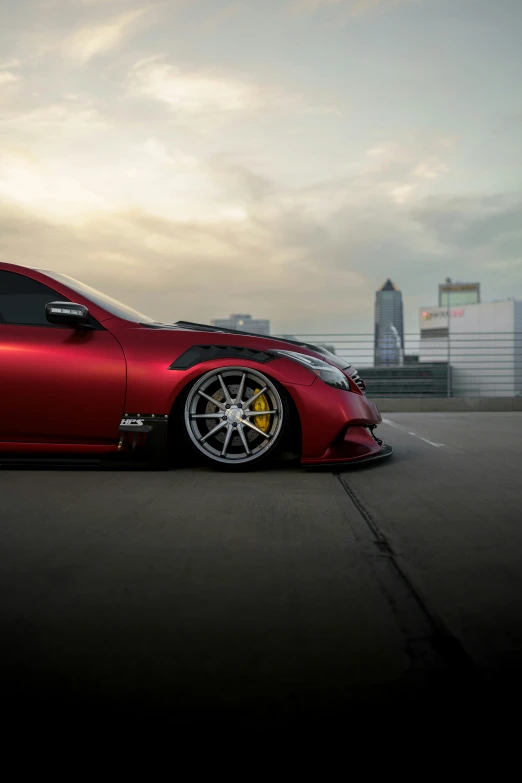 a red car on the road in front of a building