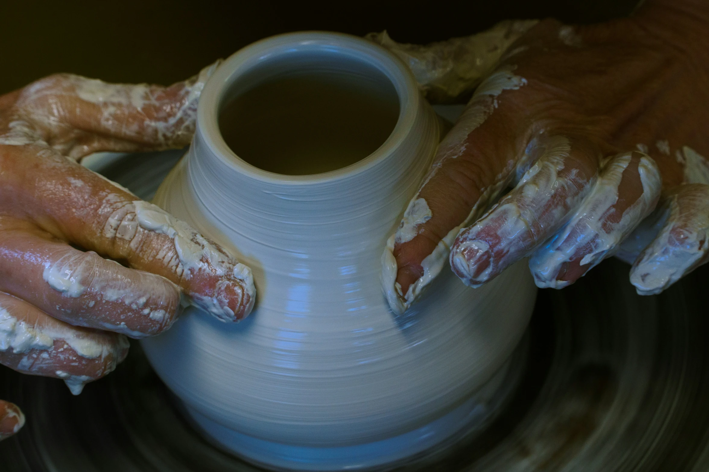 a person is making pottery with their hands