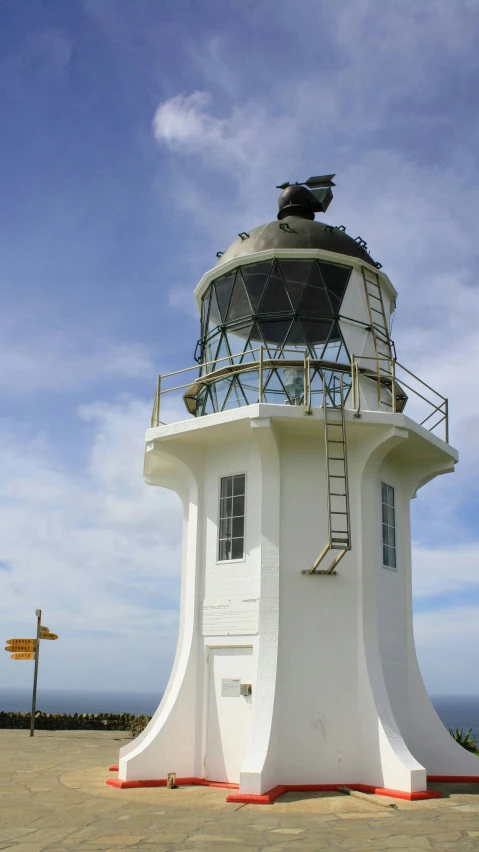 a white lighthouse on top of a sandy beach