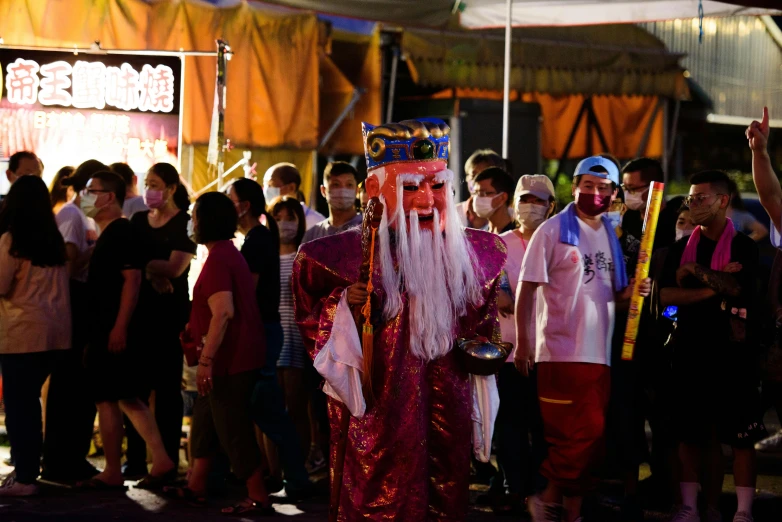 some people standing around and wearing masks and costumes