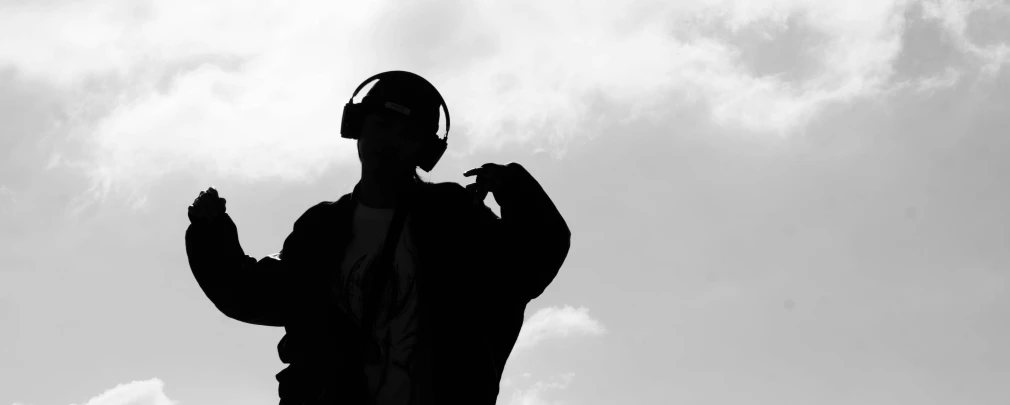 a man with headphones standing near a sky