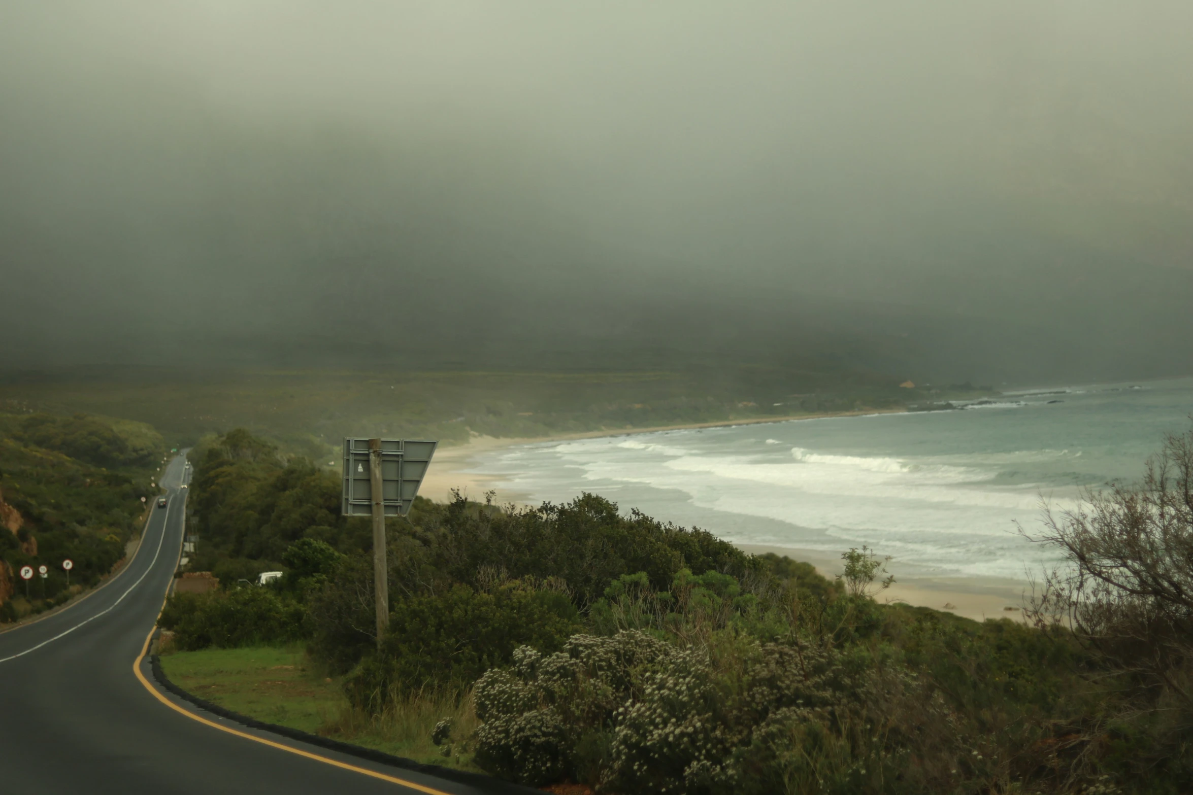 a highway passing by a beach on a foggy day