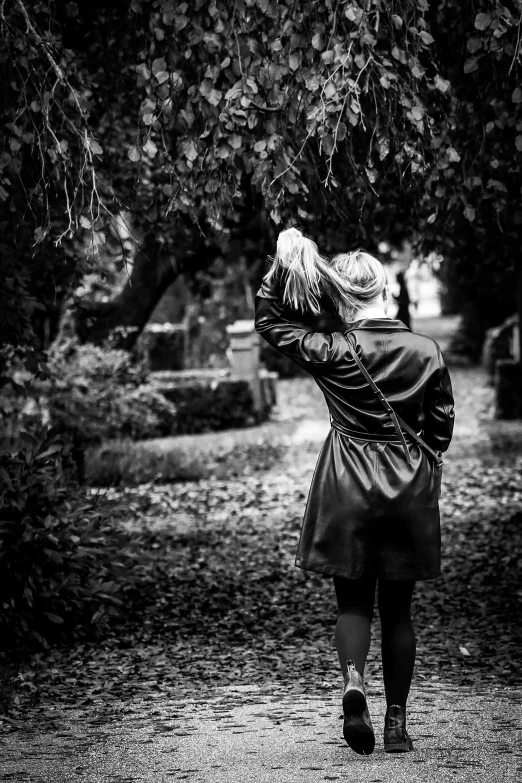 a woman walking down a path towards a park