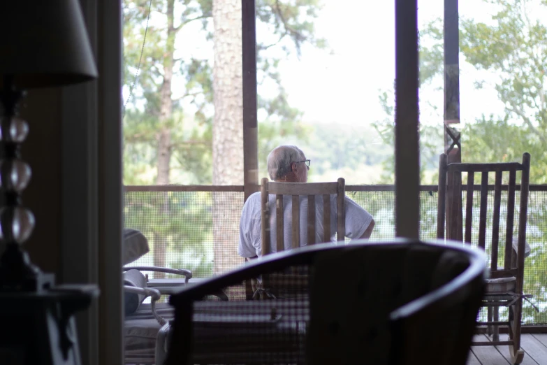 a person sitting on a porch looking out the front door