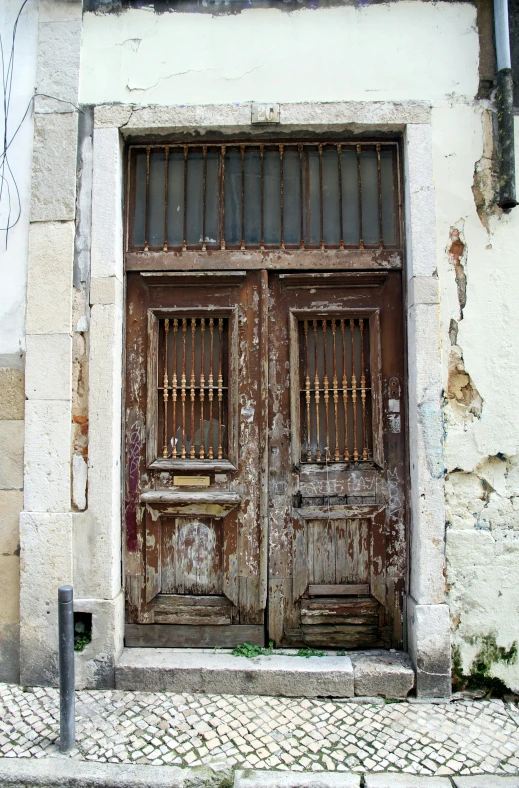 two wooden doors on the side of a building