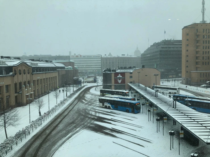 a street view shows snow, buildings and empty traffic