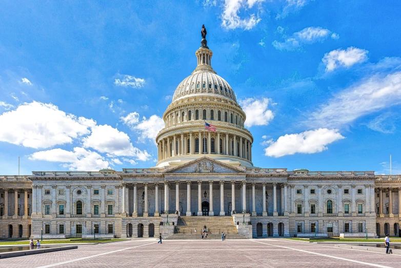 the dome of the u s capitol building is shown under a partly cloudy sky