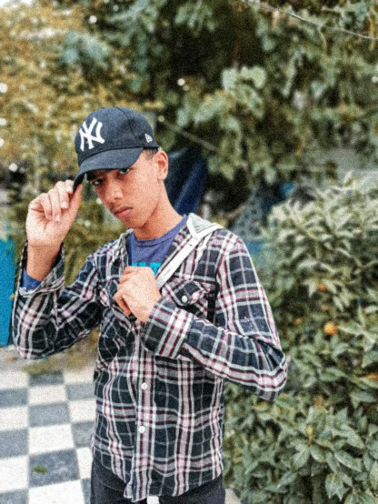 a man poses while wearing a yankees cap