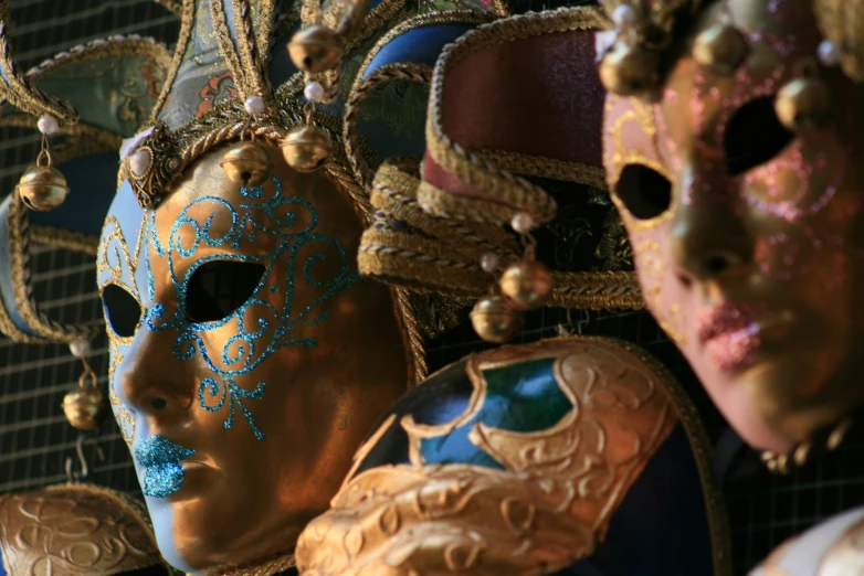 several different masks that include gold and green paint