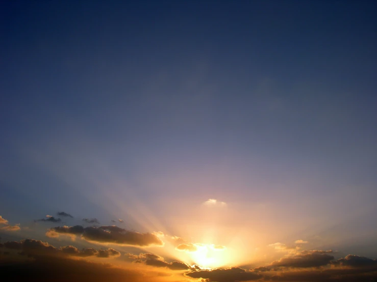 a very beautiful blue sky with clouds and sunbeams