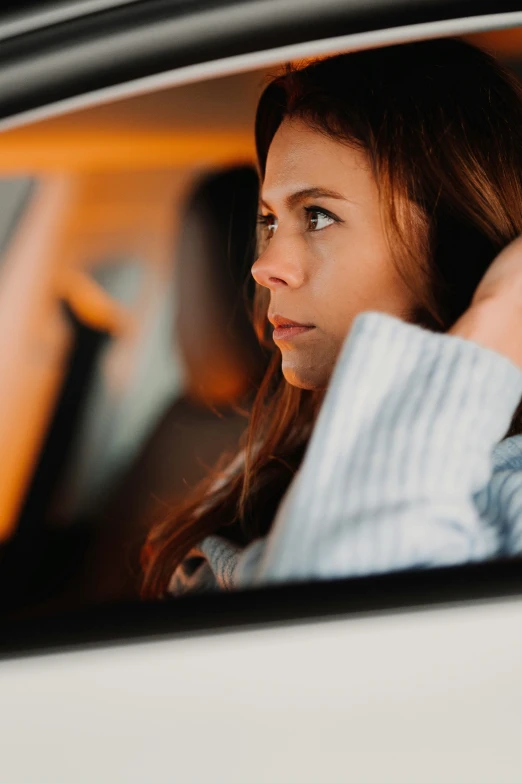 a beautiful young woman sitting in a car