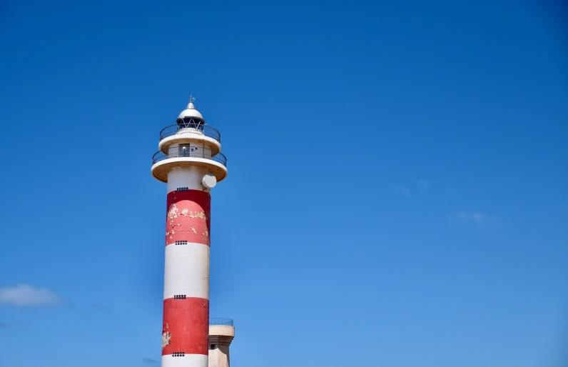 a red and white lighthouse on the shoreline