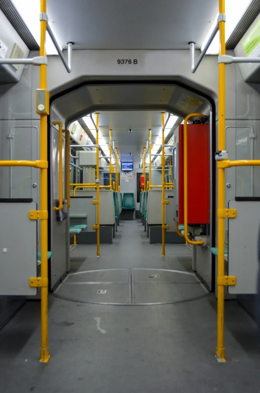 inside view of an empty subway car with yellow bars