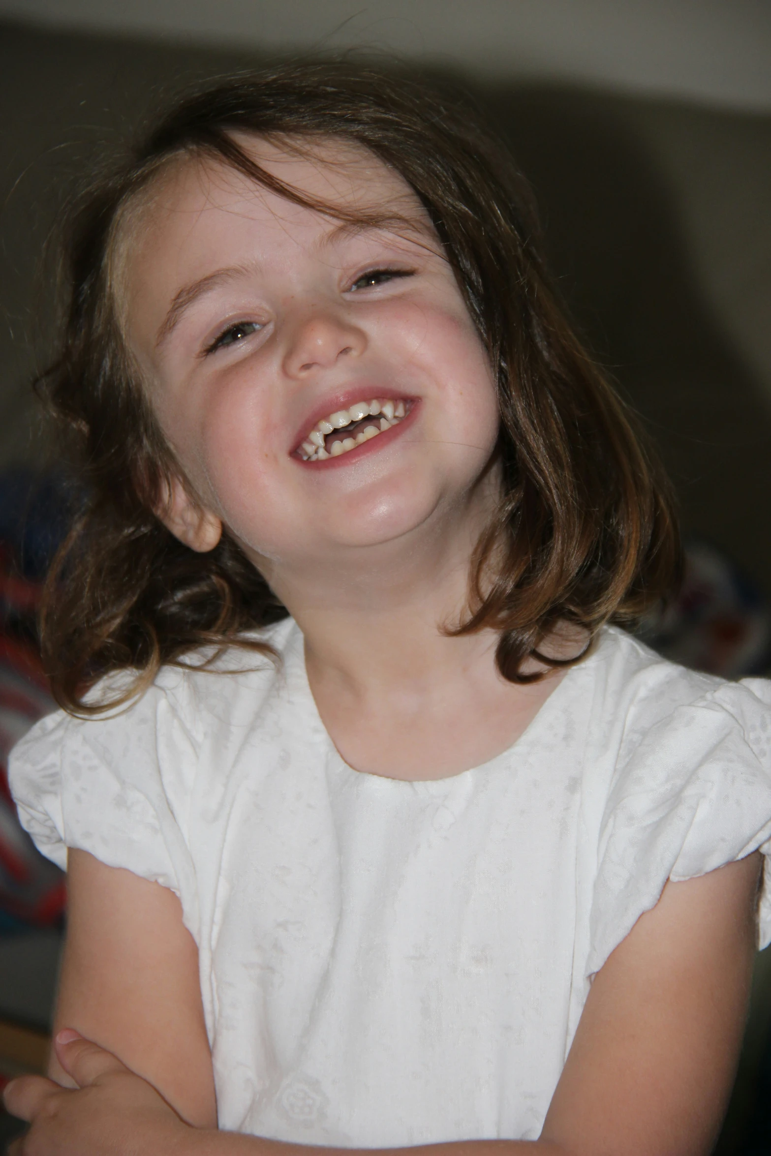 a little girl wearing white smiles at the camera