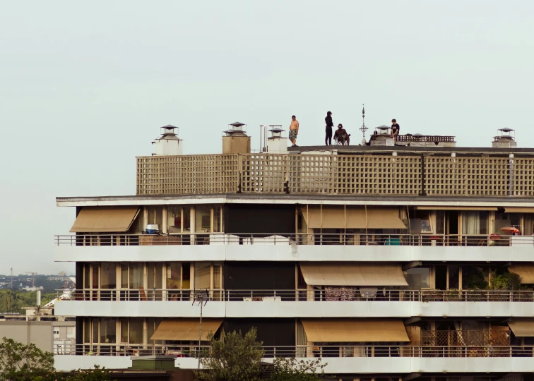 people stand on the roof of an apartment building