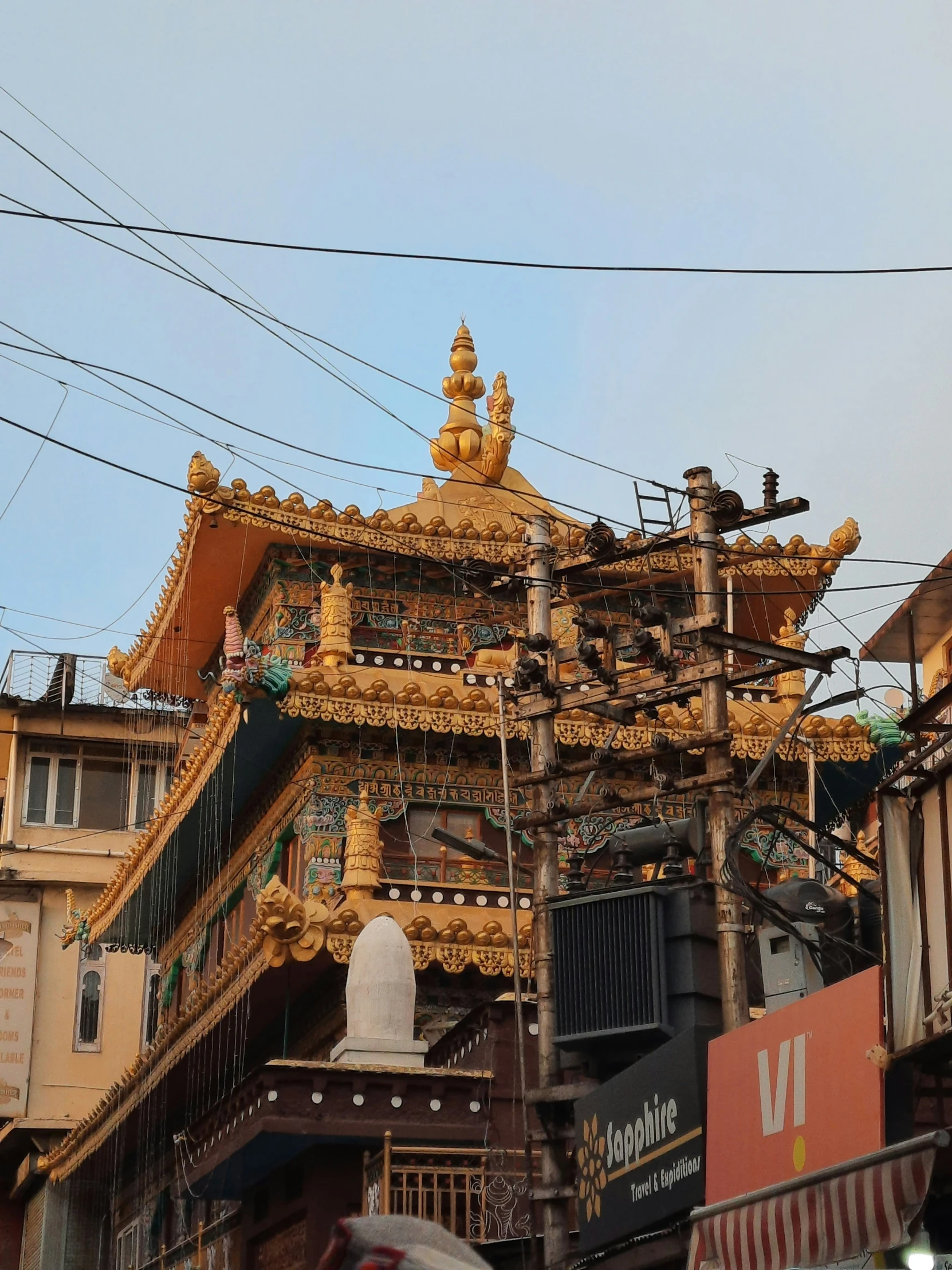 a tall structure with statues on top sitting next to buildings