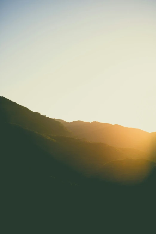 a lone ski jumper in silhouette on a hilltop