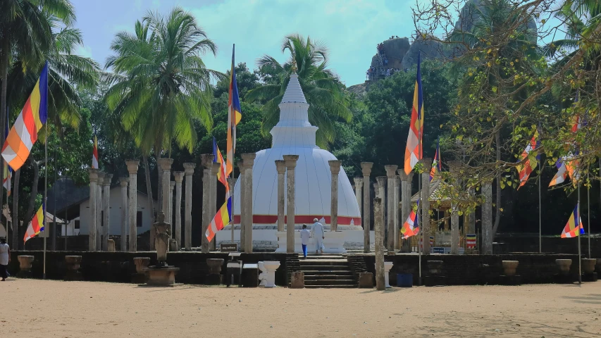 several flags fly on the sand and around a statue