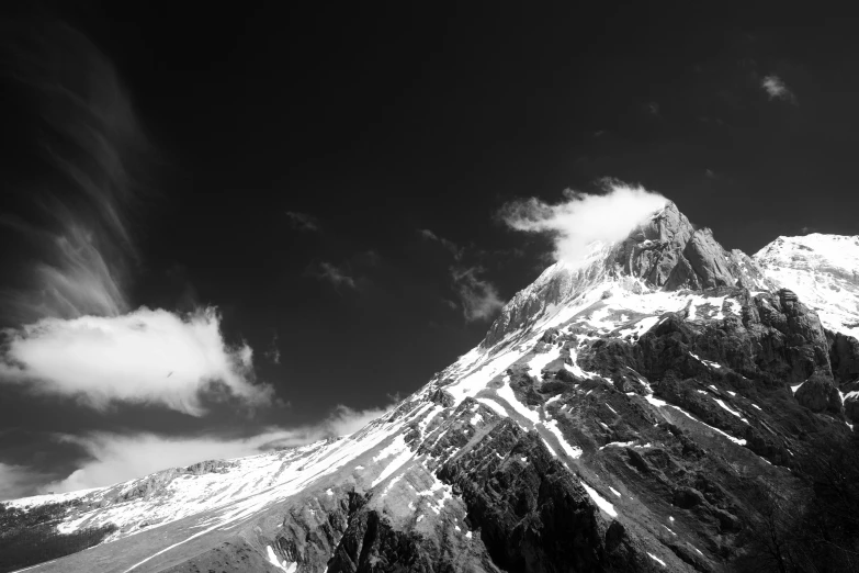 the mountain is tall and the clouds are in black and white