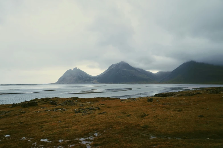 a small boat out on a body of water surrounded by mountains