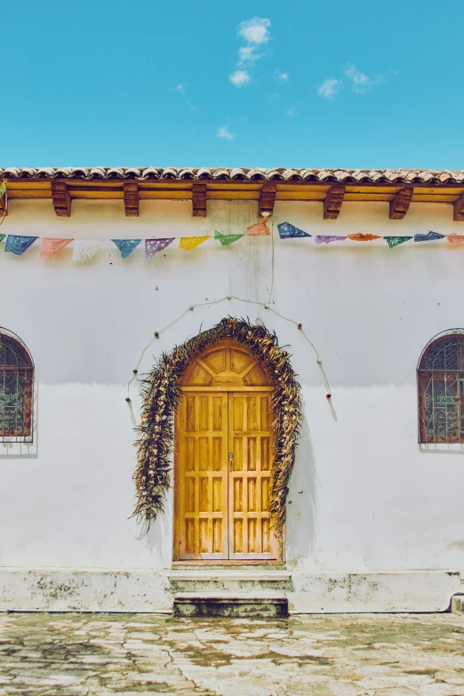 the front door of a house painted in beige and with windows above it