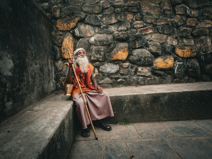 an elderly person sitting down with an old pole and basket