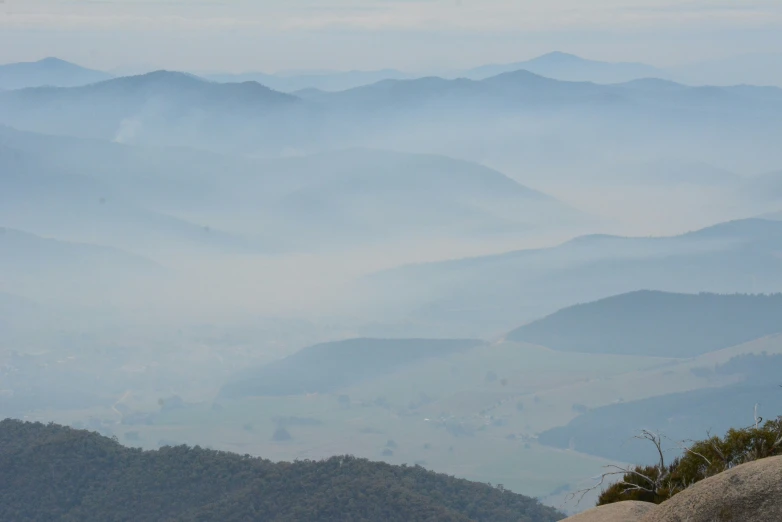 the mountains are covered in fog and hazy skies