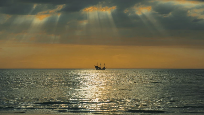 a view of the ocean at sunset, with a ship coming towards shore