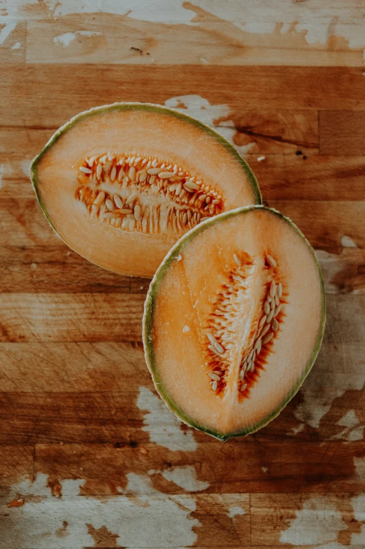 a piece of melon with a few leaves on top of it