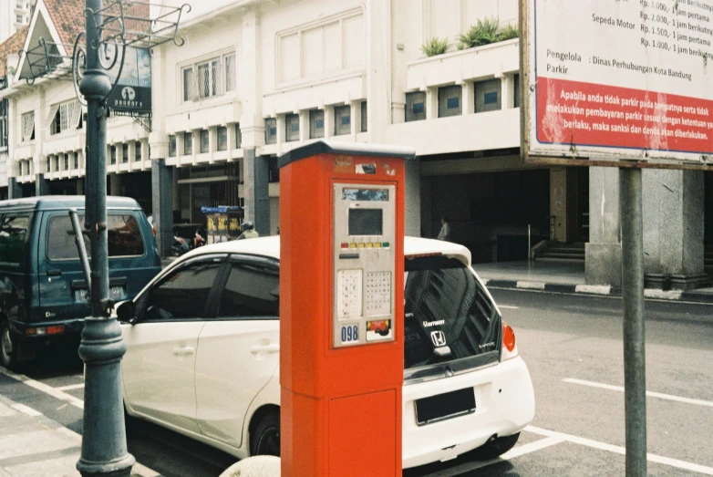 a car is parked at an orange parking meter