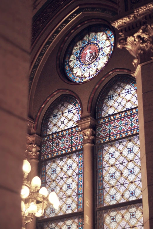 two very large stained glass windows by a chandelier