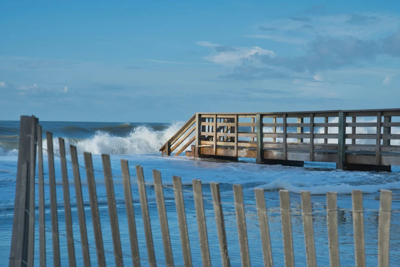 a po taken over the ocean with a wooden fence