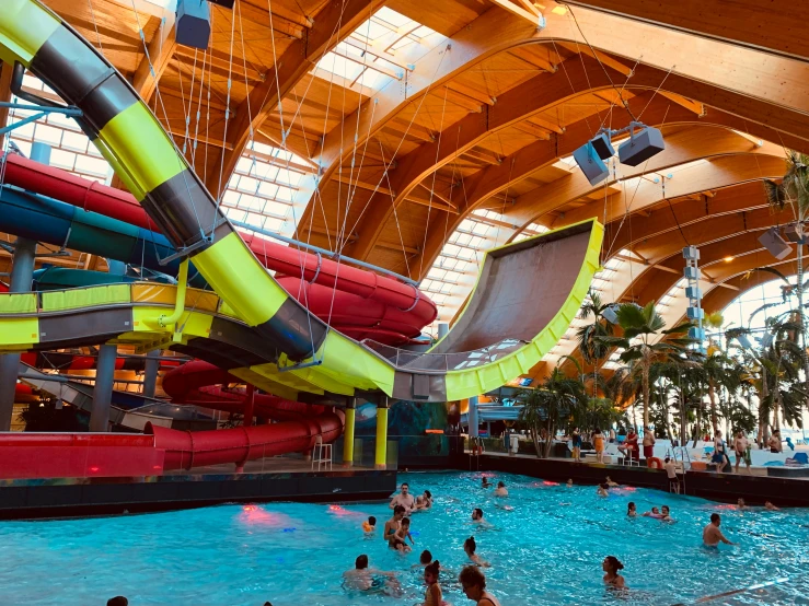 an indoor water park with many people playing in it