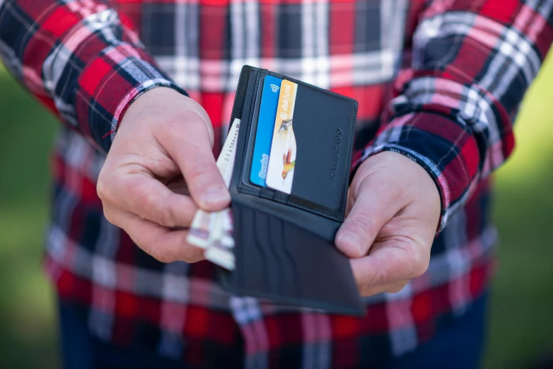 a person holding an empty credit card wallet in their hand