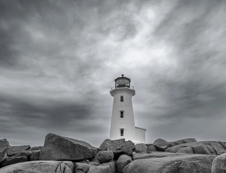 a lighthouse sitting on the side of some rocks