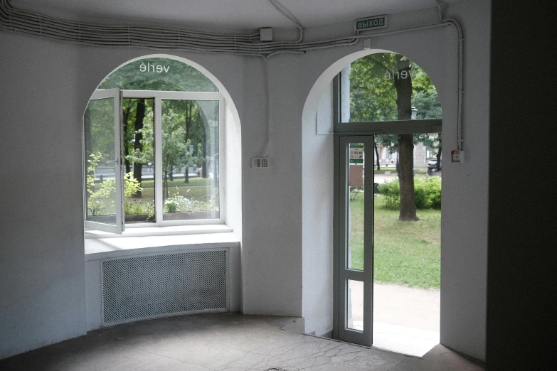 two arched windows next to each other in front of a large window