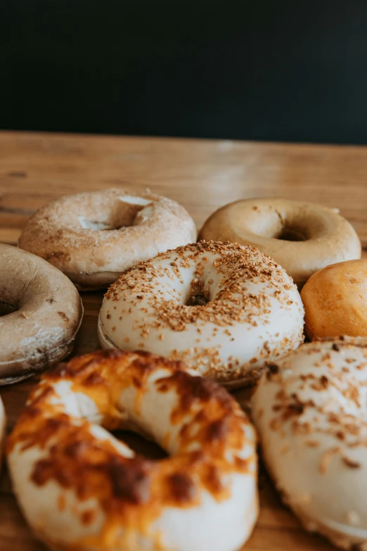 a table topped with assorted doughnuts on top of a wooden table