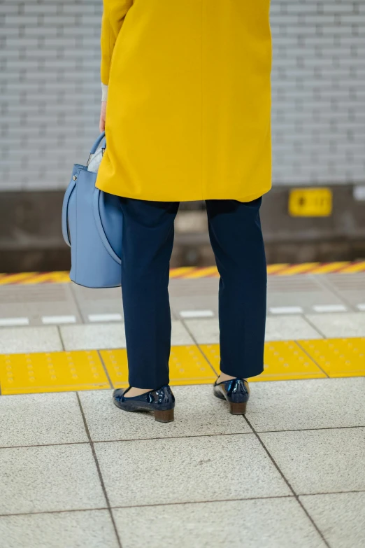 a person standing near a wall and subway area