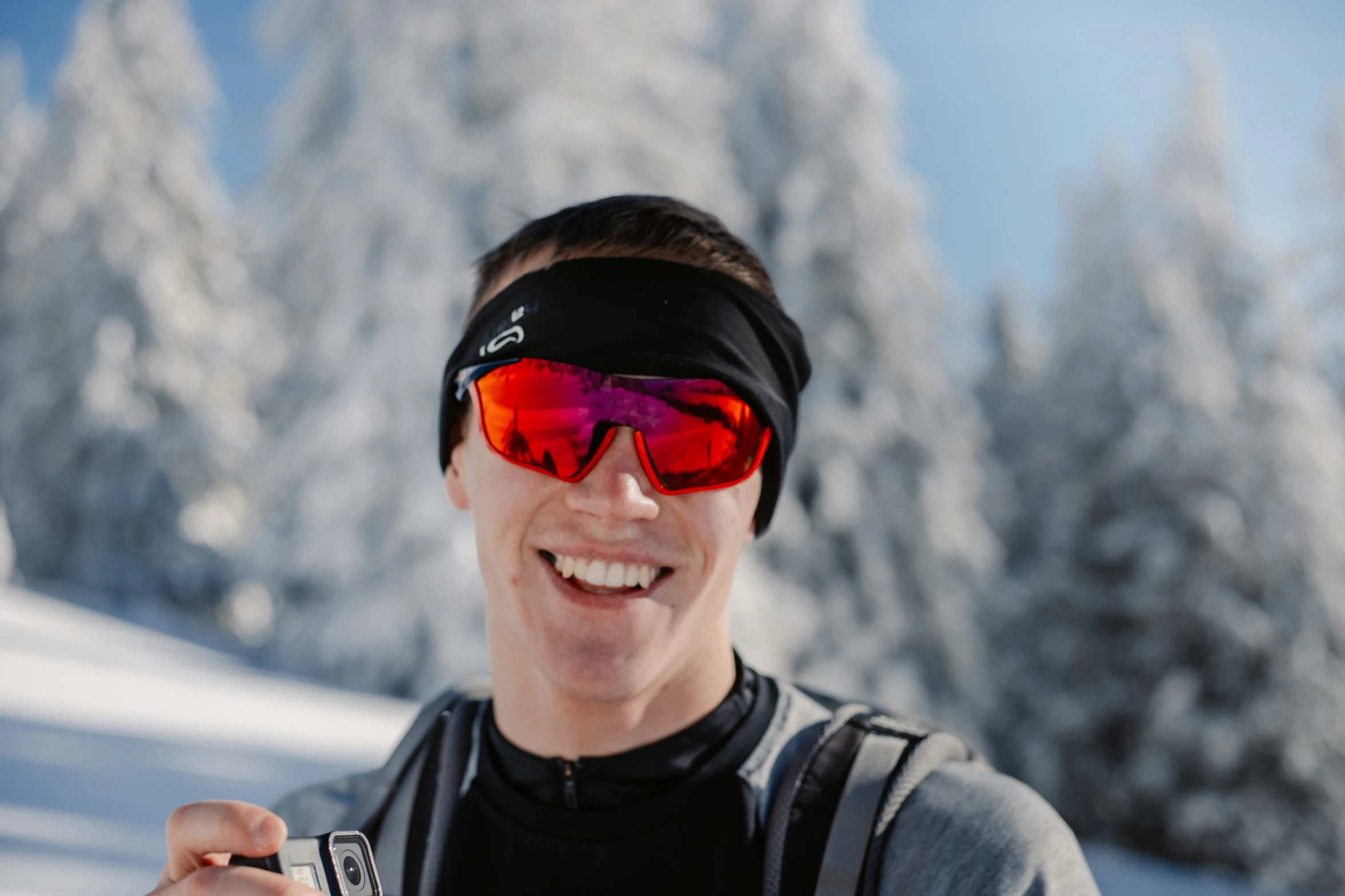 a man on the ski slope holding up his phone