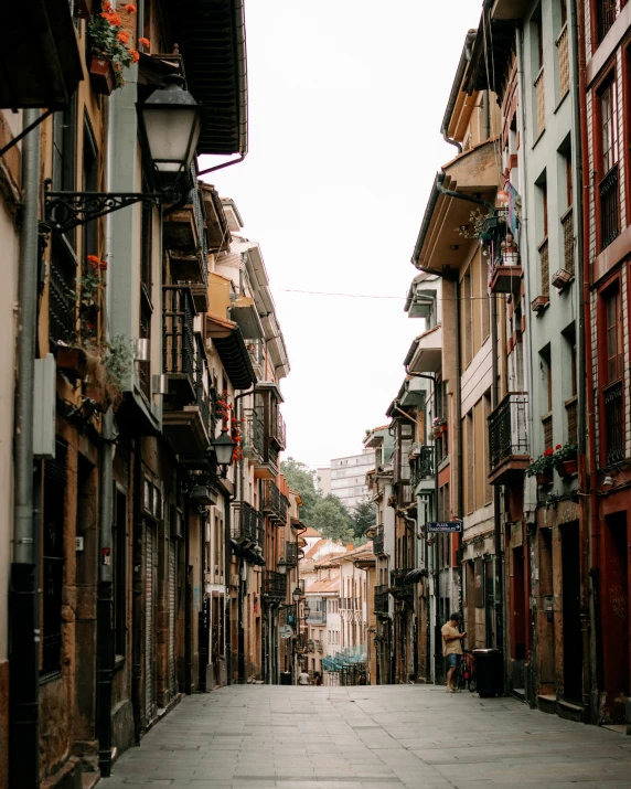 an empty street in a european country surrounded by tall buildings