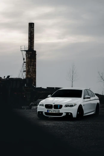 a bmw is parked in front of an industrial plant